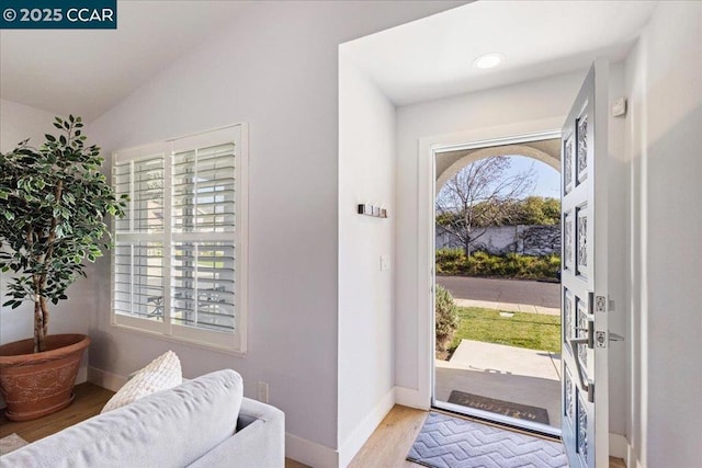 entrance foyer featuring vaulted ceiling and light hardwood / wood-style flooring