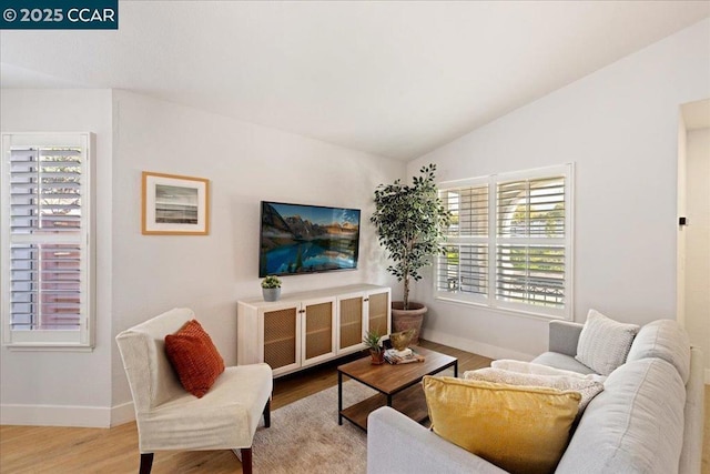 living room featuring lofted ceiling and light wood-type flooring