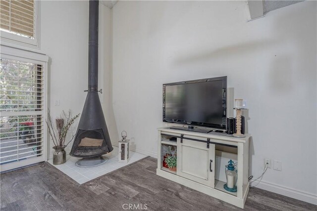 unfurnished living room featuring dark wood-type flooring and a wood stove