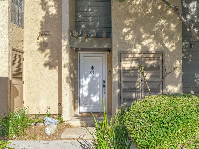 doorway to property featuring stucco siding