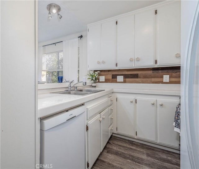 kitchen with white dishwasher, light countertops, white cabinets, a sink, and dark wood finished floors