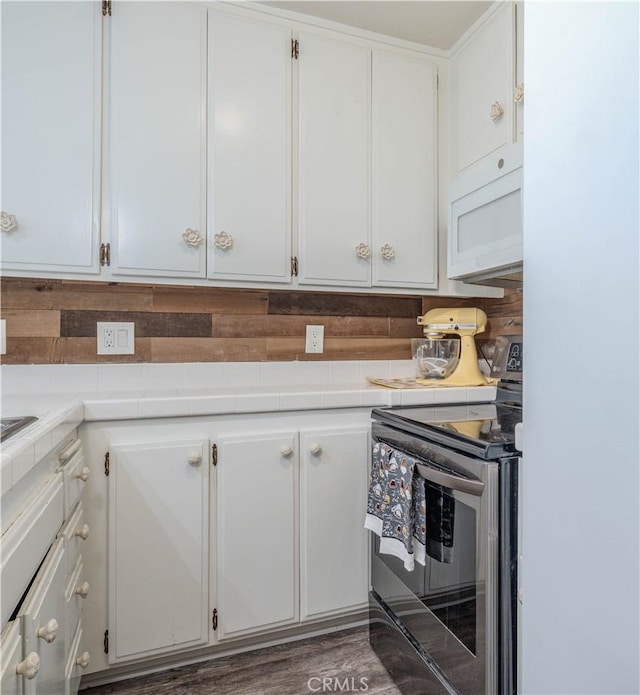 4900 E Chapman Ave Unit 24, Orange, CA 92869 - kitchen featuring stainless steel electric range, white microwave, tile counters, white cabinets, and backsplash