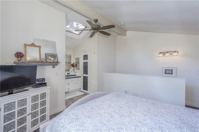 4900 E Chapman Ave Unit 24, Orange, CA 92869 - bedroom with ensuite bath, a skylight, baseboards, a textured ceiling, and a ceiling fan