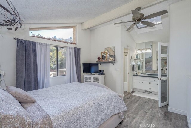 bedroom featuring a textured ceiling, ceiling fan, lofted ceiling with beams, and hardwood / wood-style floors