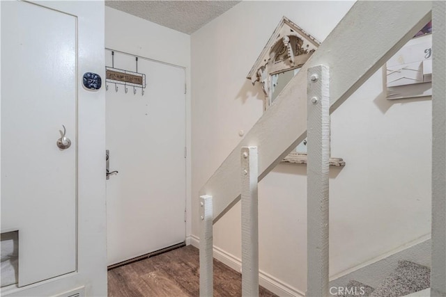 foyer featuring a textured ceiling and wood finished floors