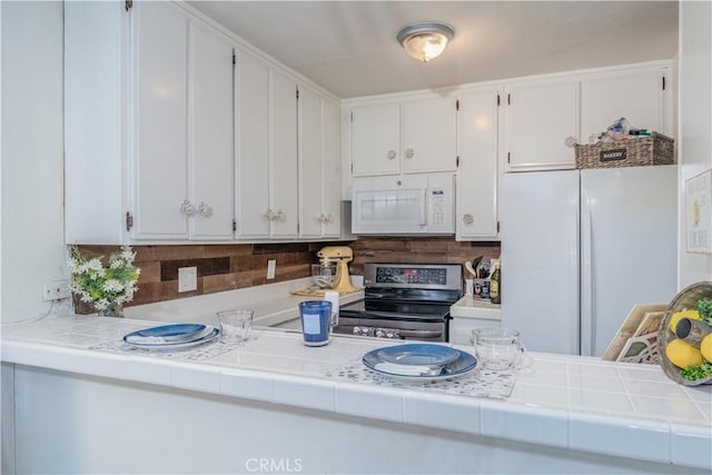 kitchen featuring tile countertops, white appliances, and white cabinetry