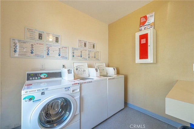 community laundry room featuring baseboards and washing machine and clothes dryer