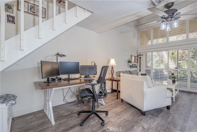 office area featuring baseboards, a textured ceiling, ceiling fan, and wood finished floors