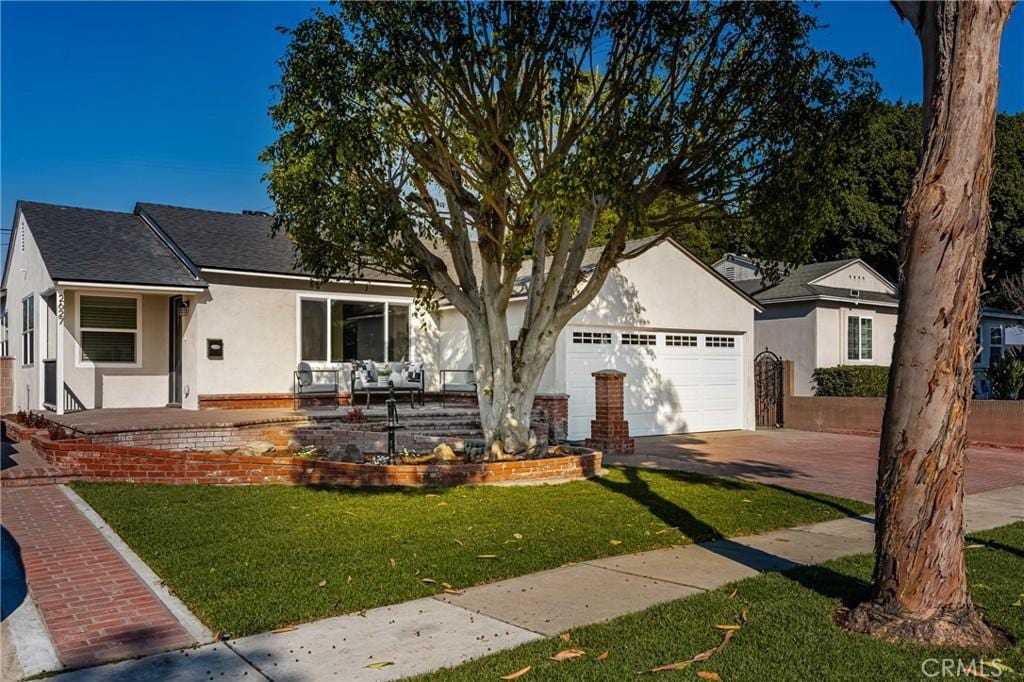 single story home featuring a front yard and a garage