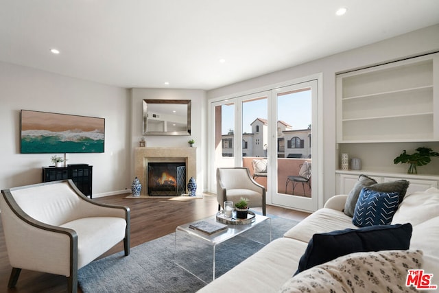 living room with built in features and hardwood / wood-style flooring