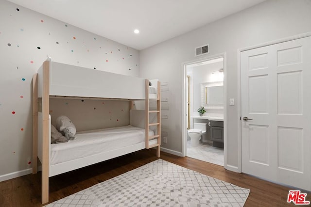 bedroom with dark hardwood / wood-style flooring and connected bathroom