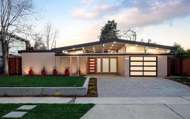 contemporary house featuring a garage and a yard