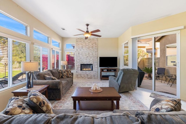 living room with a fireplace, ceiling fan, and light tile patterned floors