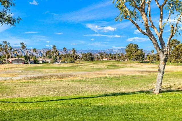 surrounding community with a yard and a mountain view