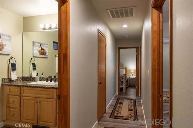 hallway with sink and hardwood / wood-style floors