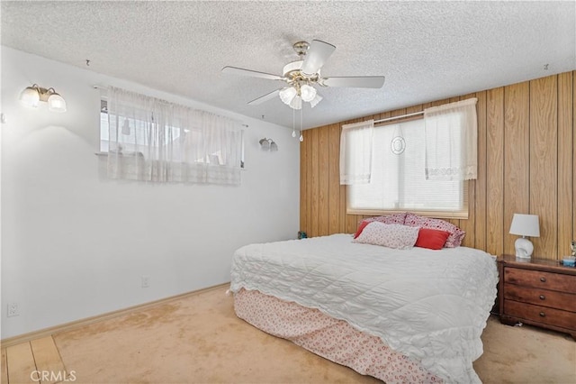 bedroom featuring a textured ceiling, ceiling fan, carpet floors, and wooden walls