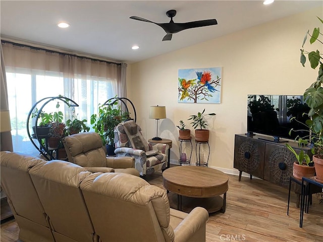 living room with lofted ceiling, ceiling fan, and light hardwood / wood-style floors