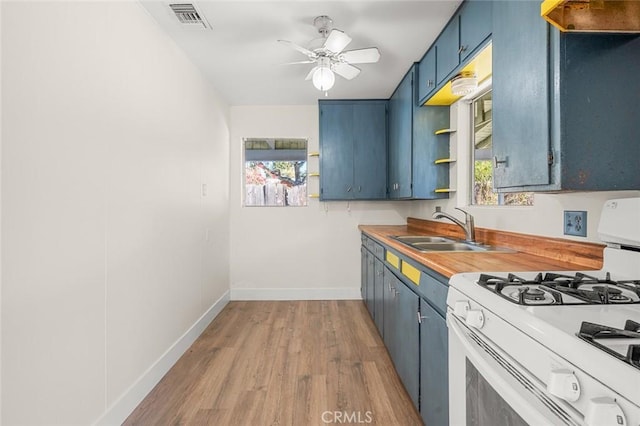 kitchen featuring light hardwood / wood-style floors, ceiling fan, white range with gas cooktop, blue cabinets, and sink