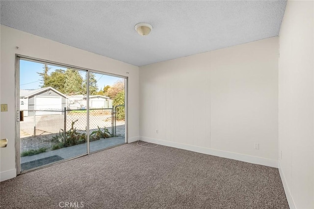 carpeted empty room with a textured ceiling