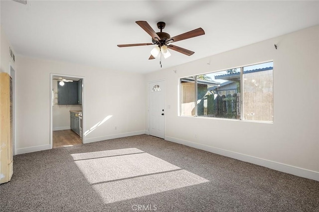 unfurnished bedroom featuring ensuite bath, ceiling fan, and carpet