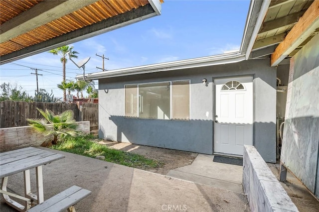 view of exterior entry featuring a patio area