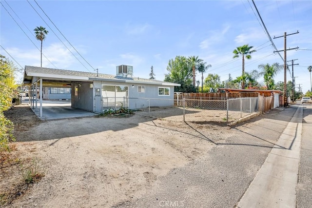 view of front of property with central AC unit and a carport