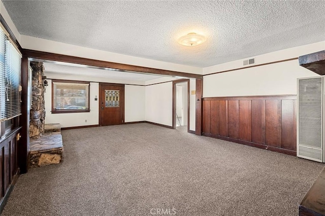 interior space with a textured ceiling and wooden walls