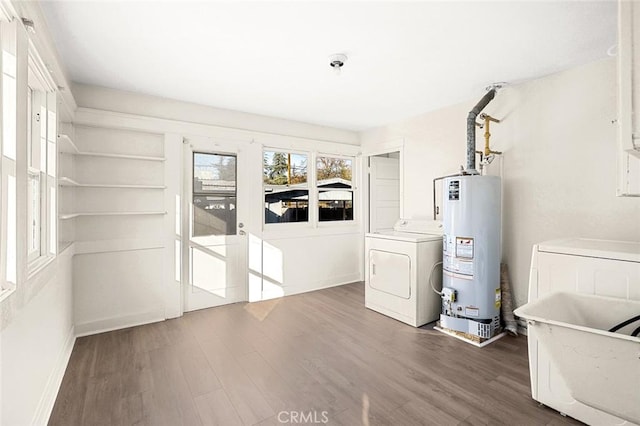 laundry area with washing machine and dryer, sink, dark hardwood / wood-style floors, and gas water heater