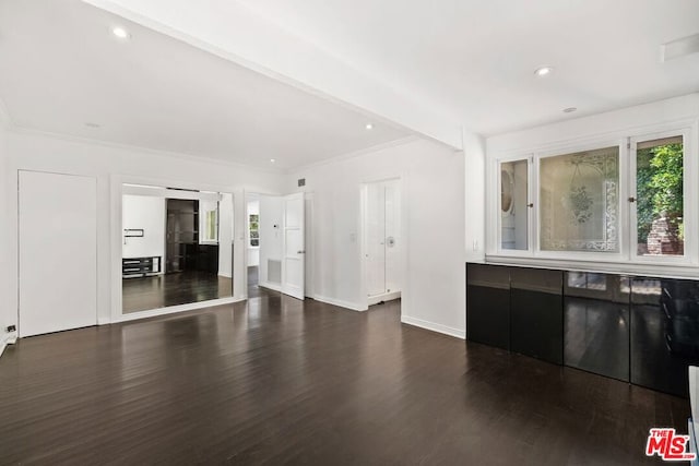 unfurnished living room with ornamental molding and dark hardwood / wood-style floors