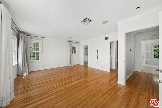 spare room featuring light hardwood / wood-style floors and crown molding