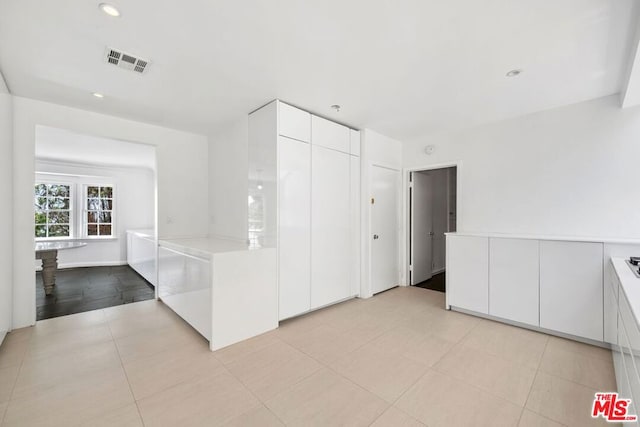 kitchen with white cabinets and light tile patterned floors