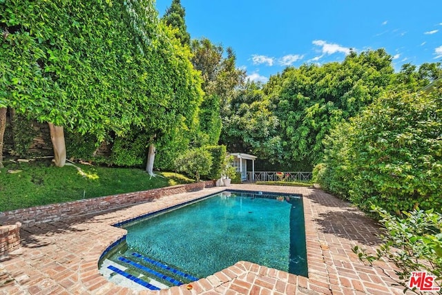 view of swimming pool featuring a patio area and an outbuilding