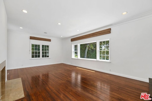 spare room with crown molding and dark wood-type flooring