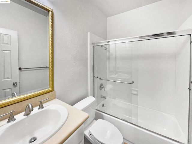 full bathroom with enclosed tub / shower combo, vanity, and toilet