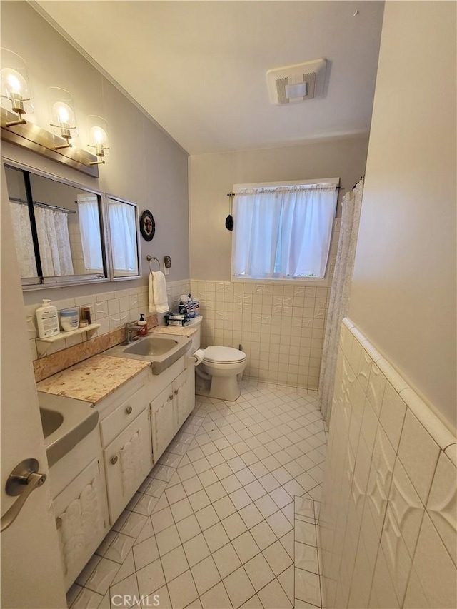 bathroom with tile walls, tile patterned flooring, toilet, and vanity