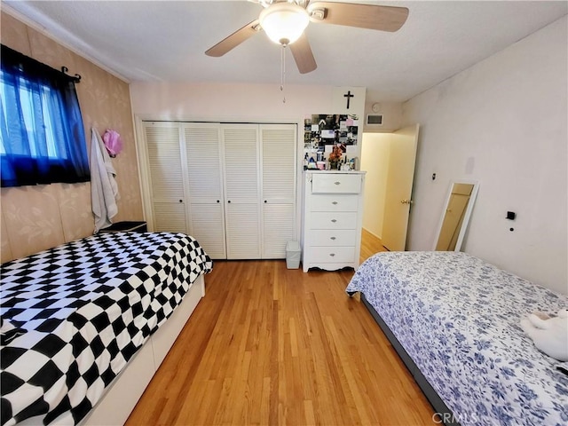 bedroom with a closet, ceiling fan, and light hardwood / wood-style flooring