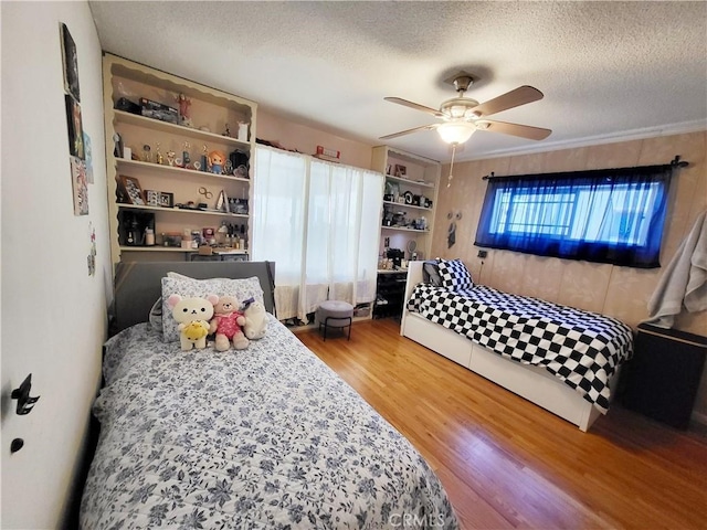 bedroom featuring ceiling fan, a textured ceiling, and hardwood / wood-style flooring