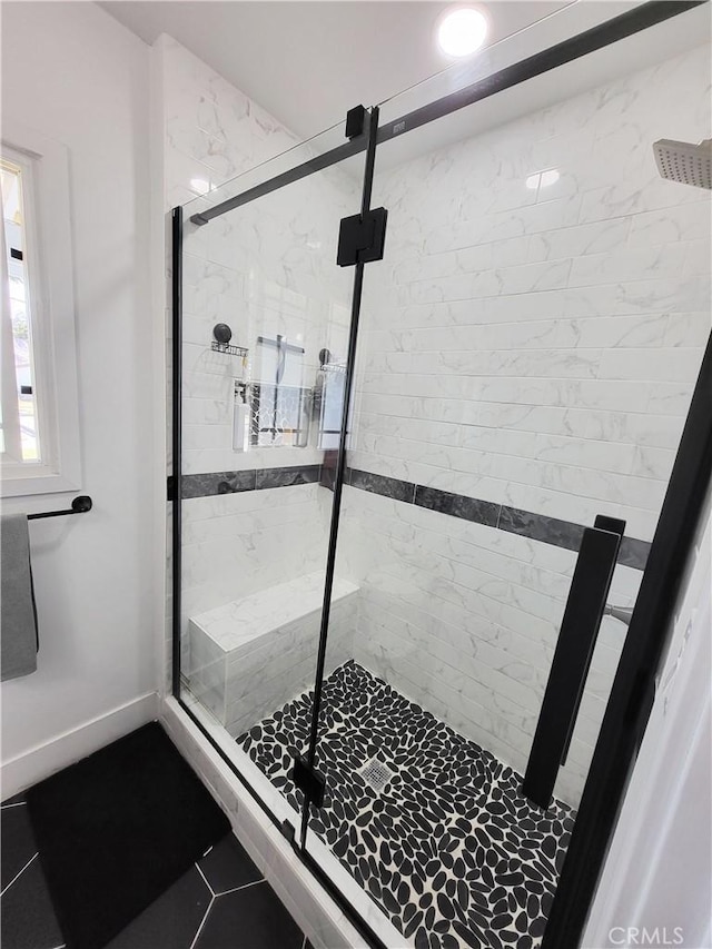 bathroom featuring a shower with shower door and tile patterned floors