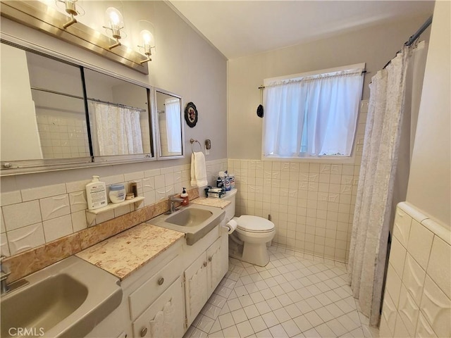 bathroom with tile walls, tile patterned flooring, vanity, and toilet