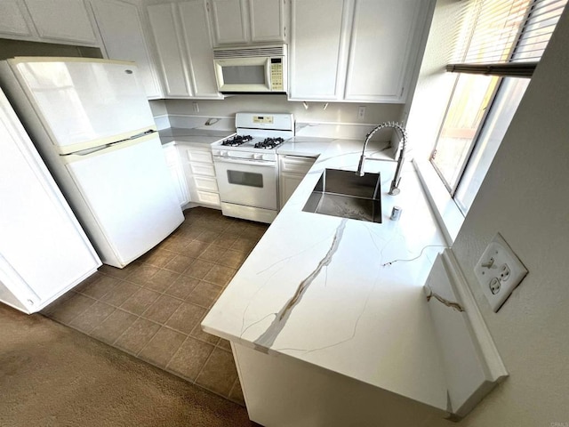 kitchen featuring sink, white appliances, and white cabinets