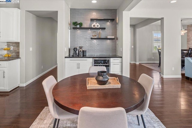 dining space featuring beverage cooler, dark hardwood / wood-style floors, and bar area