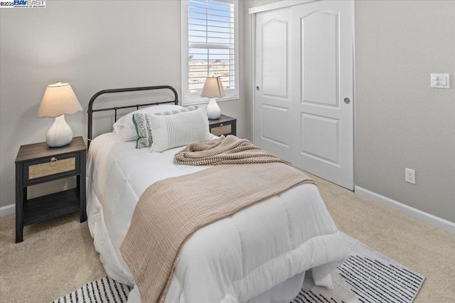 bedroom featuring a closet and light carpet