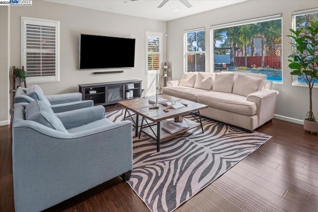 living room with dark hardwood / wood-style flooring and ceiling fan