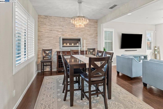 dining space with dark hardwood / wood-style floors and a notable chandelier