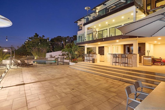 view of patio with a bar and a fenced in pool