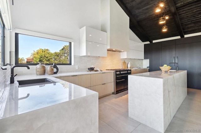 kitchen with sink, pendant lighting, an island with sink, and black range with gas stovetop