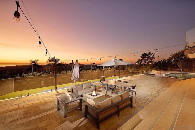 patio terrace at dusk featuring an outdoor fire pit