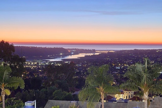 aerial view at dusk featuring a water view