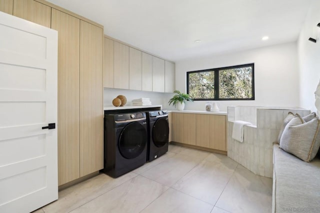 laundry room featuring cabinets, washing machine and clothes dryer, and light tile patterned floors