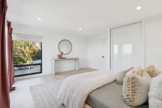 bedroom with access to exterior and light hardwood / wood-style flooring